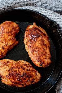 Three chicken breasts in a cast iron skillet