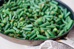 saute pan filled with green beans stir-fried in a sesame soy glaze