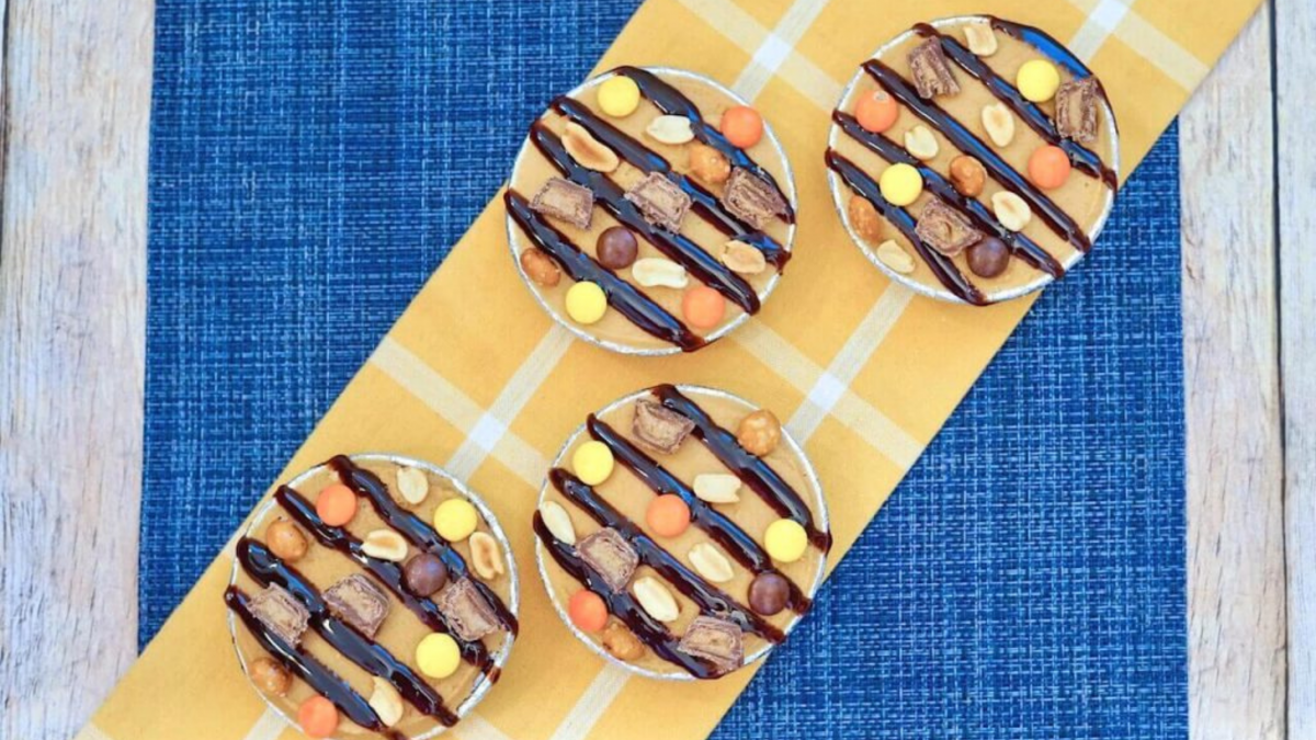 four mini Reese's Peanut Butter Pies sitting on a yellow checkered towel with a blue background