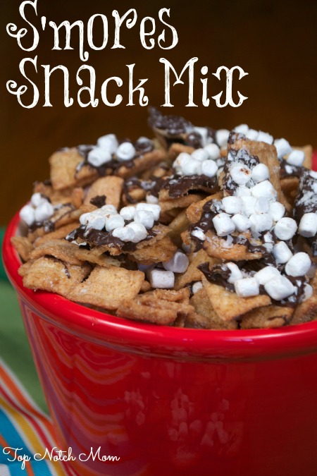 a red bowl filled with s'mores snack mix - a mix of golden graham cereal, chocolate and marshmallow bites