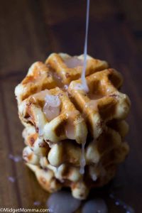 Stacked Cinnamon Roll Waffles with icing being poured on