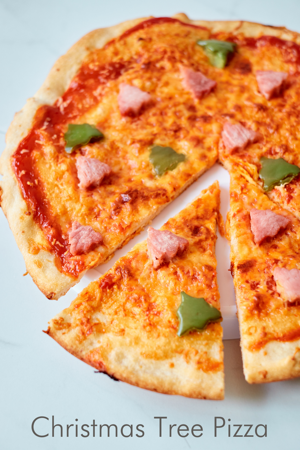 Make pizza night festive with this delicious and easy Ham and Pepper Christmas Tree Pizza! It’s the perfect holiday tradition that the kids can help make!