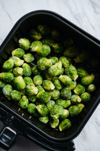sprouts in the basket of an air fryer prior to cooking