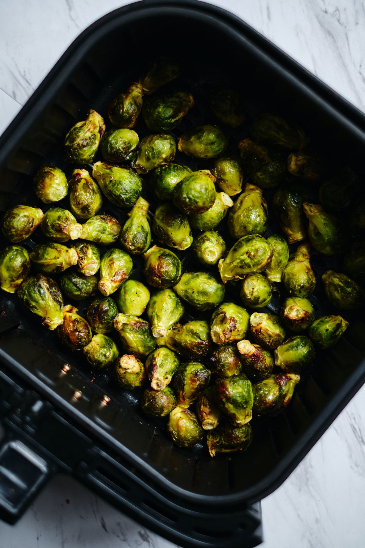 brussels in the basket of an air fryer after being cooked