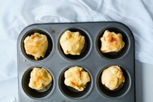 uncooked rolls sitting in a muffin tin
