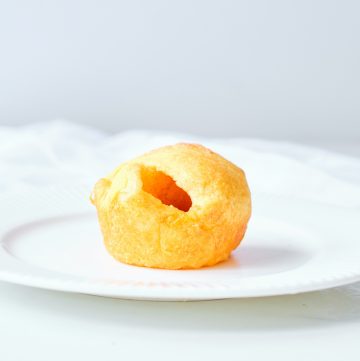 one crescent roll sitting on a round white plate