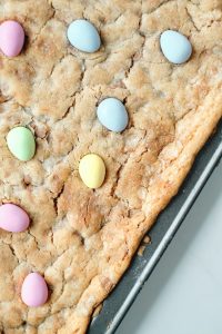 full baking sheet with uncut cookie bars topped with mini egg candies