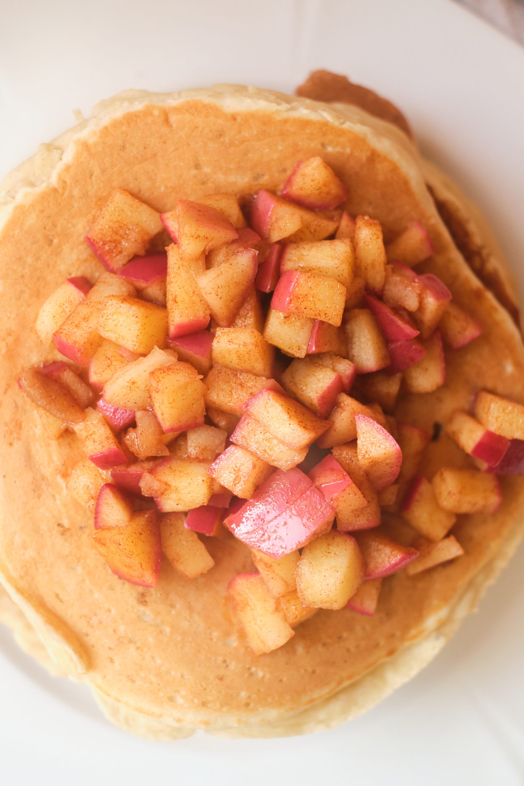 top view of apple butter pancakes topped with diced red apples lightly fried in cinnamon sugar